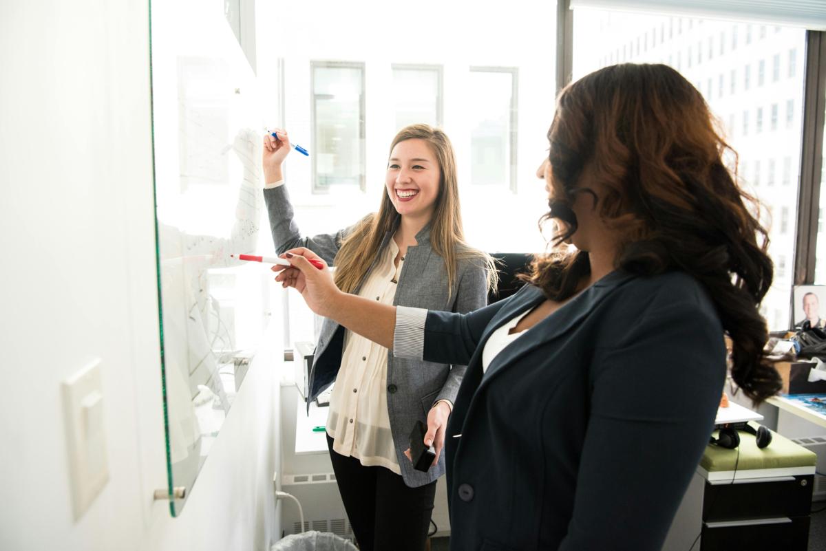 Professional women collaborating at a whiteboard